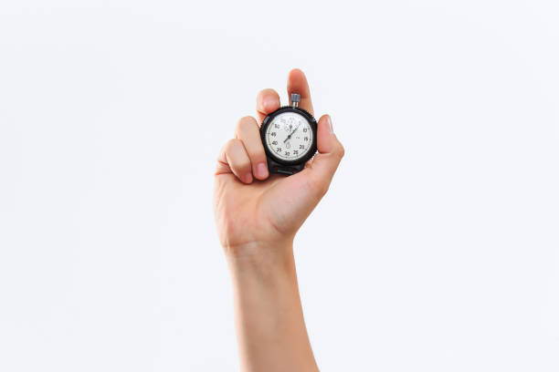 hand holding a stopwatch against a white background The male hand holding a stopwatch against a white background stopwatch photos stock pictures, royalty-free photos & images
