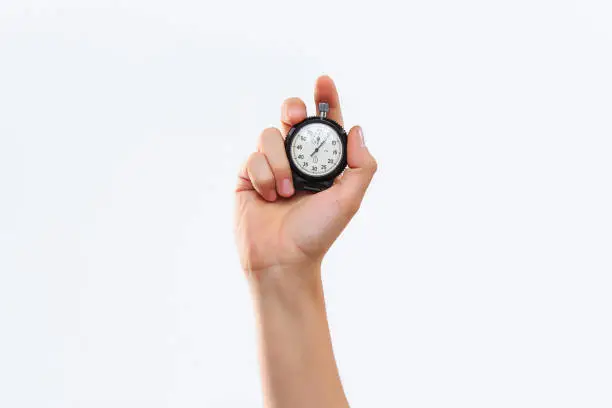 Photo of hand holding a stopwatch against a white background