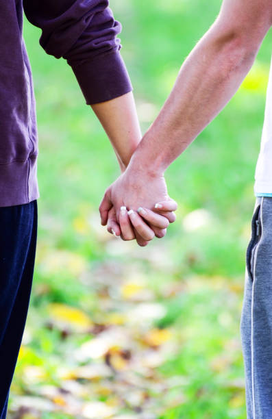istock Closeup of couple holding hands while walking in nature 650402082