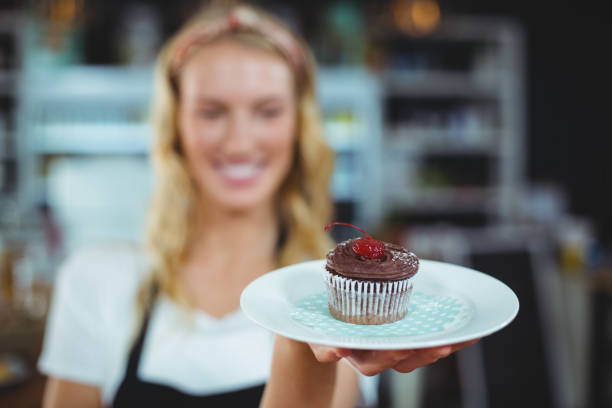 istock Waitress holding a plate of cupcake 650402258