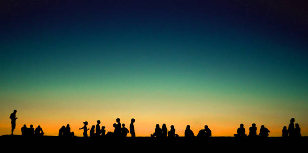 istock Group of young people sitting on wall at sunset 650428814