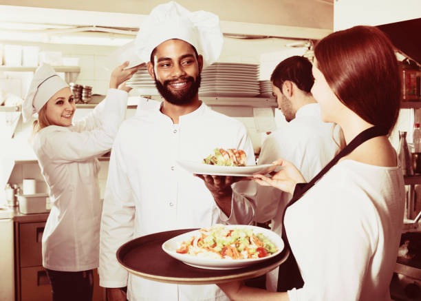 istock Waitress and cooking team in restaurant 650504474