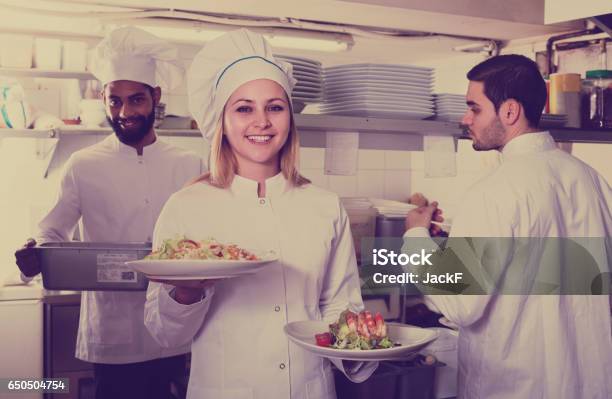 Chef And His Assistants Preparing Meal Stock Photo - Download Image Now - Crew, Kitchen, Adult