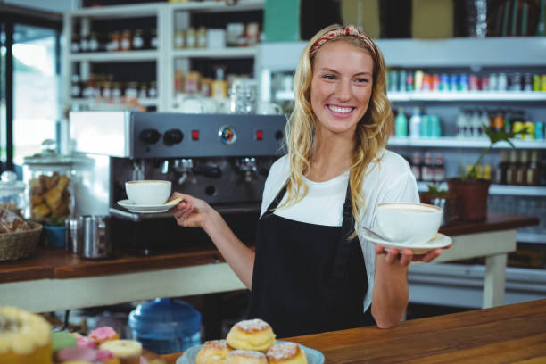 istock Smiling waitress offering cup of coffee 650514112