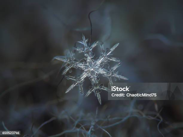 Snowflake Glitters On Dark Gray Textured Background Stock Photo - Download Image Now