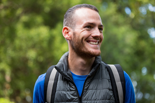 Smiling male hiker hiking in forest