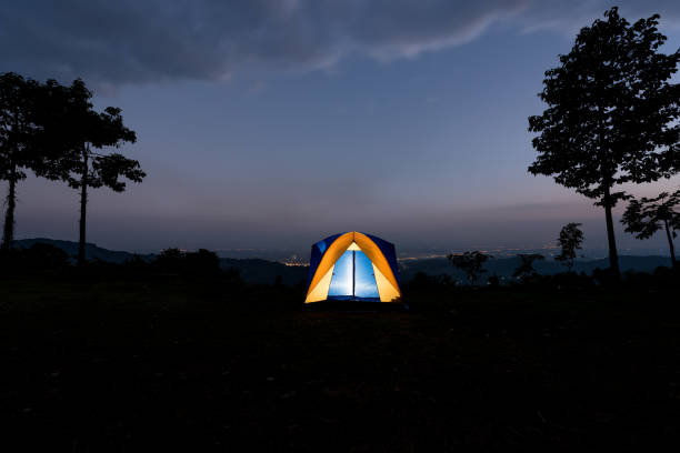 istock Yellow tent illuminated at dusk on summer mountain ridge 650530728