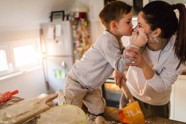 Mom's little baker Cute little baker and his mother having fun while making a bread in the kitchen baking bread photos stock pictures, royalty-free photos & images