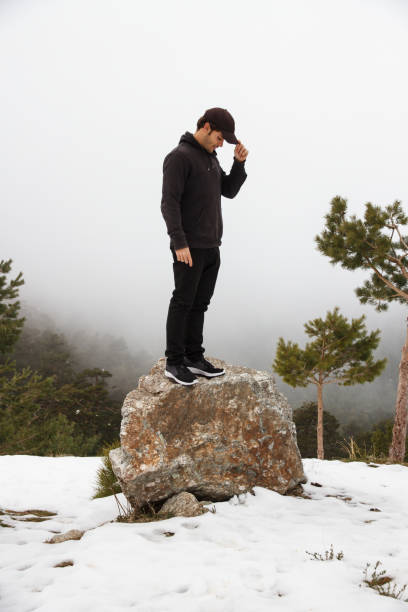 istock Young man climbed up a rock in the mountain. 650557756
