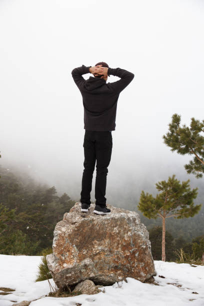 istock Young man climbed up a rock in the mountain. 650557982