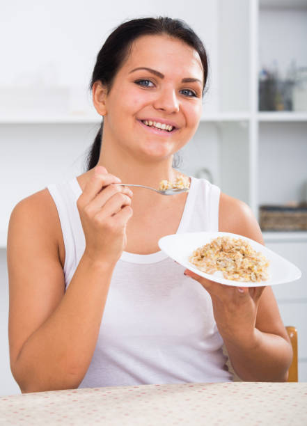istock Young woman eating breakfast 650590526