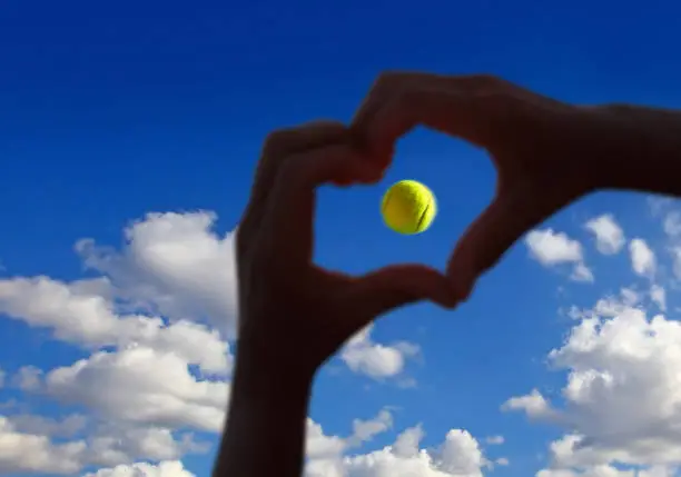 View of tennis ball midair with cloudy sky above