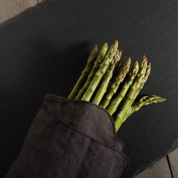 Fresh green asparagus on a elegant black slate plate