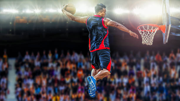 asketball Player scoring an athletic slam dunk shoot Basketball Player scoring an athletic slam dunk shoot basketball sport photos stock pictures, royalty-free photos & images
