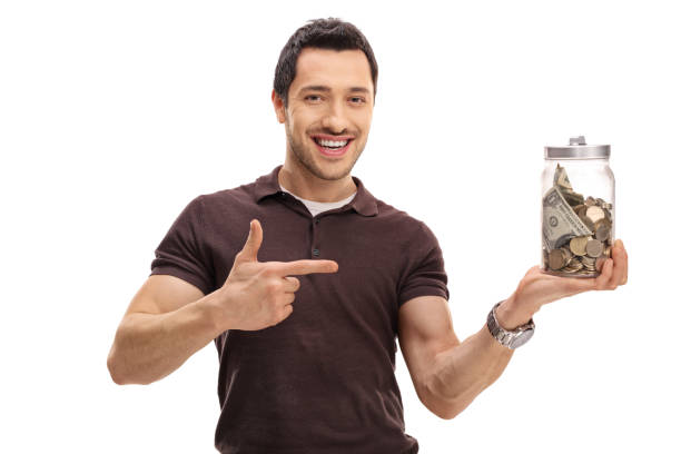 istock Happy guy holding a jar filled with money and pointing 650621178