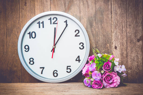 istock beautiful pink flower , clock on wooden background. 650624884