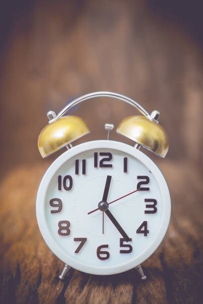 istock alarm clock on wooden background. 650624992