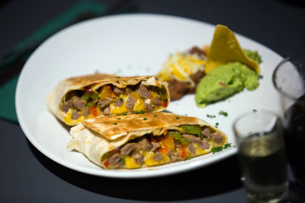 istock Mexican burrito served with guacamole on plate 650628380