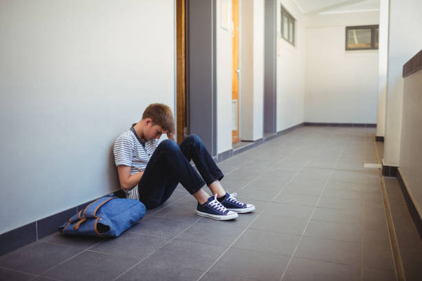 istock Sad schoolboy sitting in corridor 650629562
