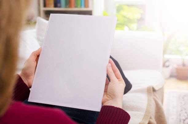 mirando un catálogo de blanco en blanco con espacio de copia - mujer leyendo periodico fotografías e imágenes de stock