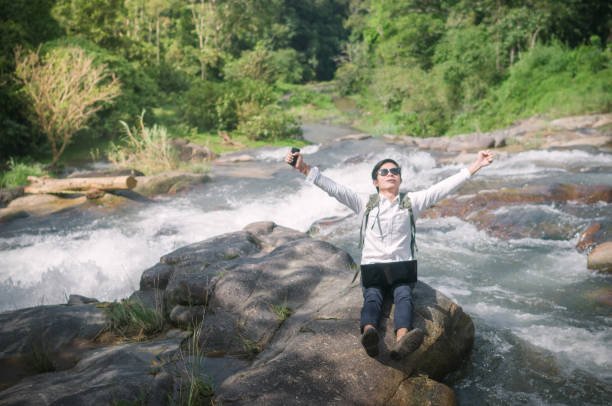 istock Businessman with backpack and laptop and phone at  waterfall  the forest. 650635464