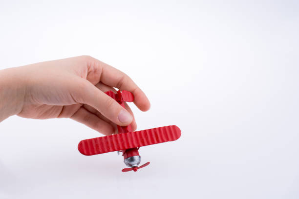 istock Hand holding a toy plane on a white background 650640854