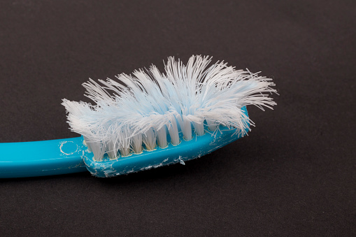Used plastic toothbrush on a black background