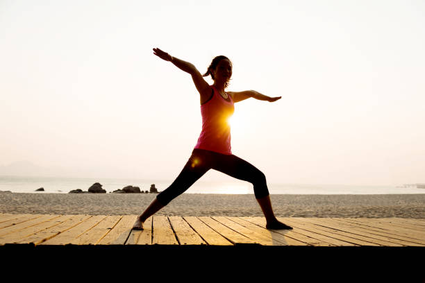 istock Woman practicing yoga at beach 650647646