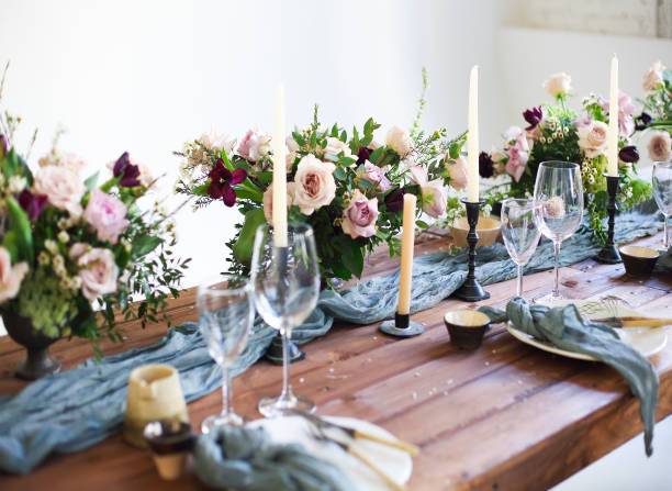 istock Bouquets of pink flowers on a table set for dinner with candles 650648924