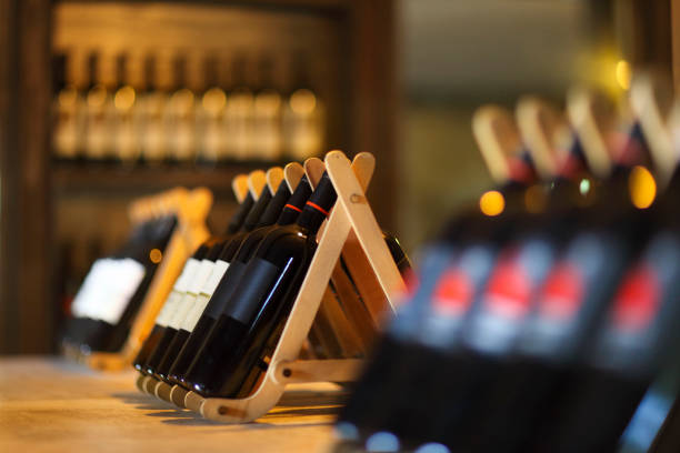 garrafas de vinho em uma prateleira de madeira. - wine cellar wine bottle grape imagens e fotografias de stock