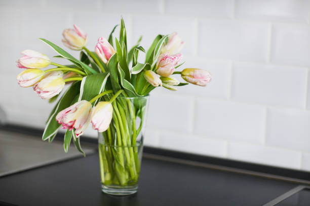 istock Pink tulips bouquet in glass vase on the kitchen 650654878