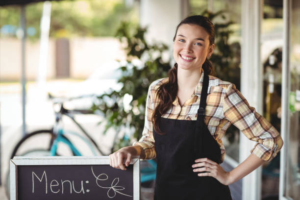 istock Waitress standing with menu board outside the cafe 650655016
