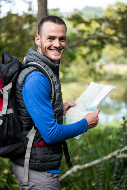 istock Male hiker holding a map in forest 650669382