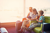 Kids waiting at the Paris airport playing with tablet