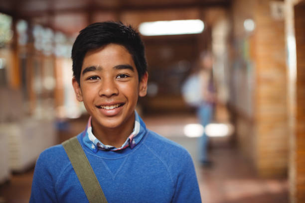 Portrait of smiling schoolboy standing in corridor Portrait of smiling schoolboy standing in corridor at school only teenage boys stock pictures, royalty-free photos & images