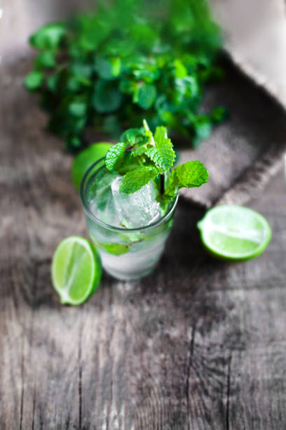 Fresh mojito drink with lime and mint leaves on  wooden rustic table