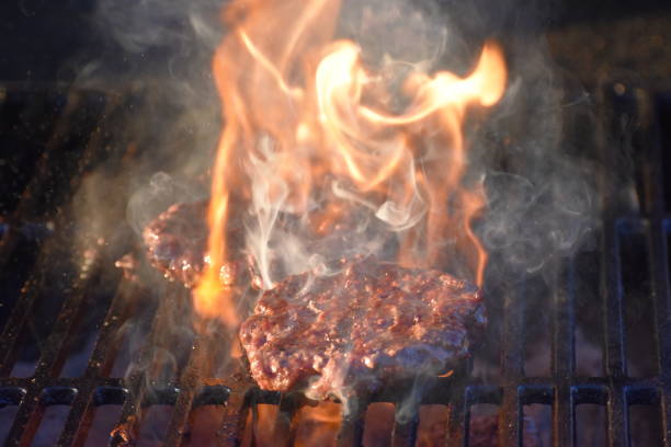istock Flaming and Smoking Hamburgers on the Grill 650682954