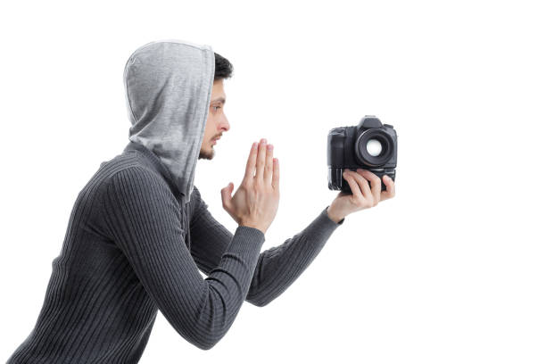 young professional photographer in shirt prays for DSLR digital camera isolated on white background