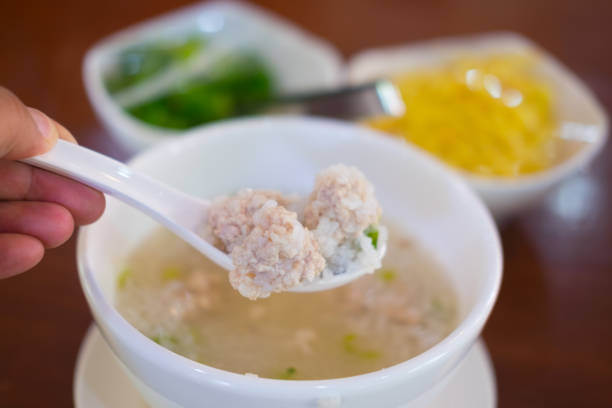 Close up minced pork on white spoon soft boiled rice, Thai style breakfast with pork