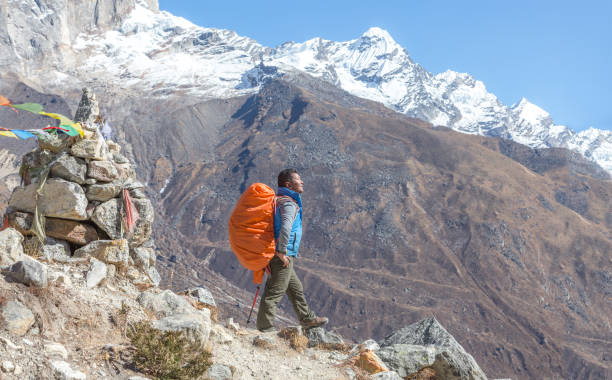 istock Nepalese Sherpa Mountain Guide staying on Footpath and buddhist flags 650695838