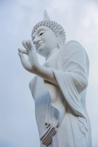 istock white buddha statue walking in Thailand 650702670