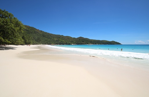People enjoy the white sandy beach Anse Lazio on Praslin Island, Seychelles.\n