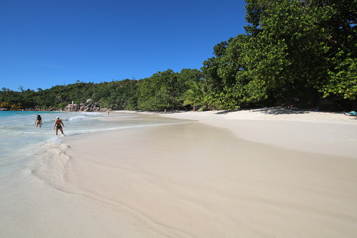 People enjoy the white sandy beach Anse Lazio on Praslin Island, Seychelles.\n