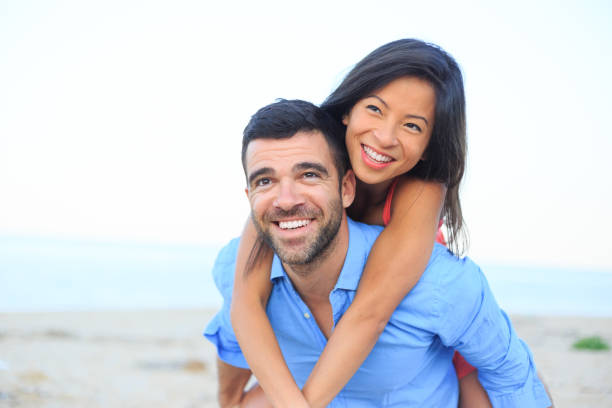 istock Couple having fun in piggyback ride on beach 650711112