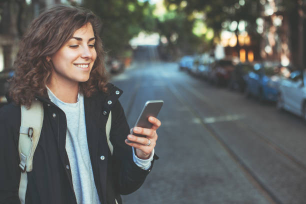 istock Woman with backpack and mobile phone in the city 650723872