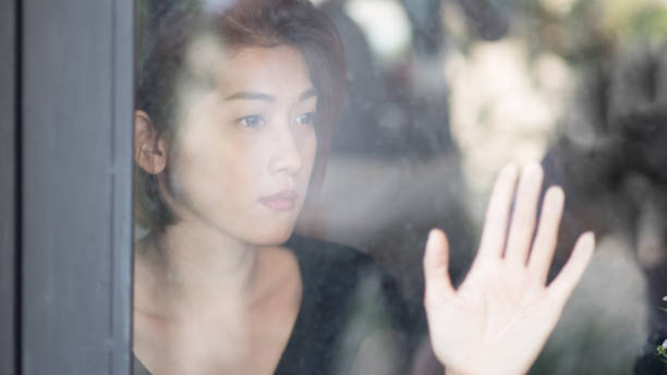 istock Sad woman looking out the window 650727078