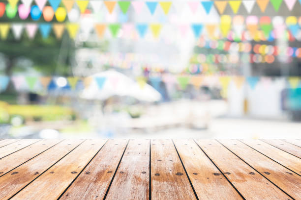 Empty wooden table with party in garden background blurred. stock photo