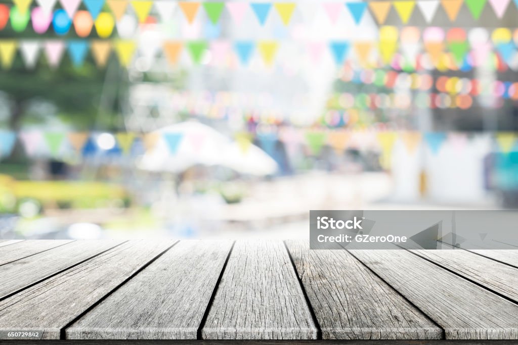 Empty wooden table with party in garden background blurred. Picnic Table Stock Photo