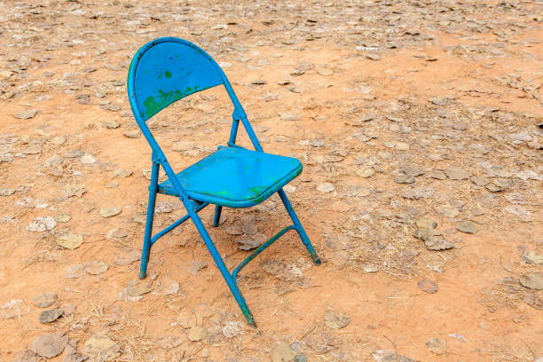 istock Old rusty blue chair leave alone in abandoned dried backyard. 650730814