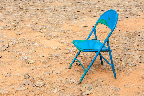 istock Old rusty blue chair leave alone in abandoned dried backyard. 650731260